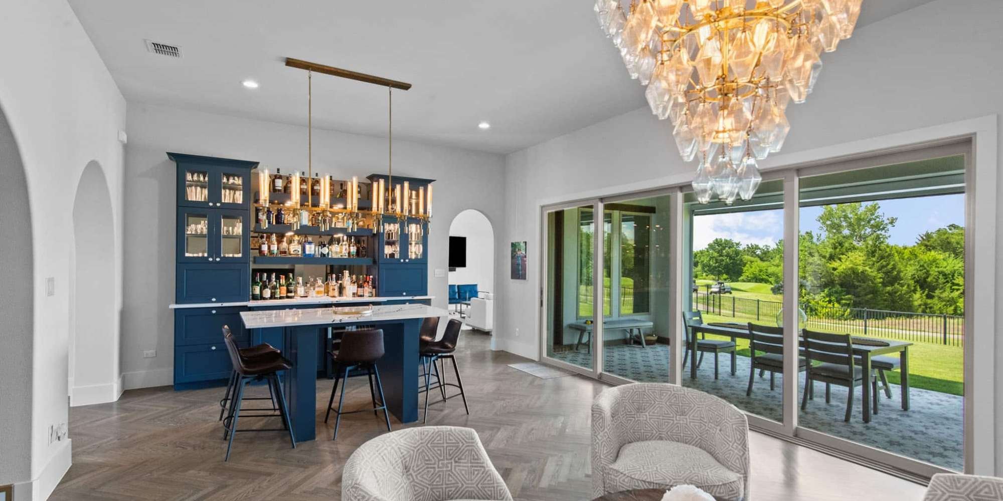 Image of home bar remodel with custom cabinetry, chandelier, and indoor outdoor living space in Collin County by Elite Remodeling