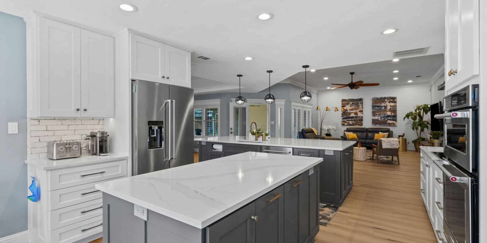 Image of modern kitchen remodel with large island, white cabinets, and open living space in Collin County by Elite Remodeling