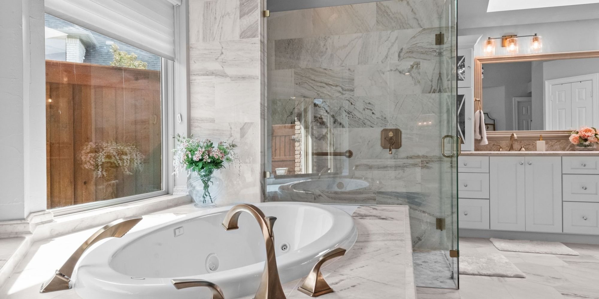 Image of luxury bathroom remodel with soaking tub, glass shower, and marble finishes in Collin County by Elite Remodeling