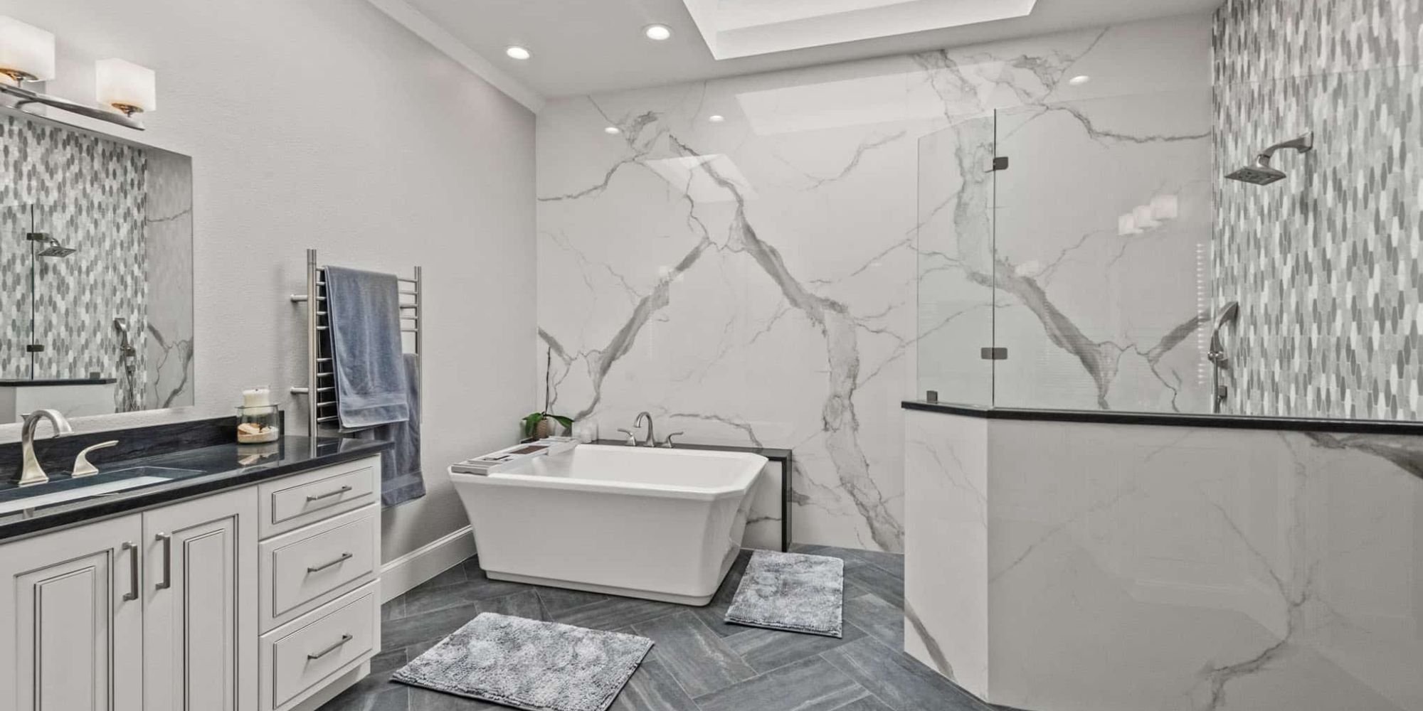 Image of modern bathroom remodel with freestanding tub, glass shower, and marble walls in Collin County by Elite Remodeling