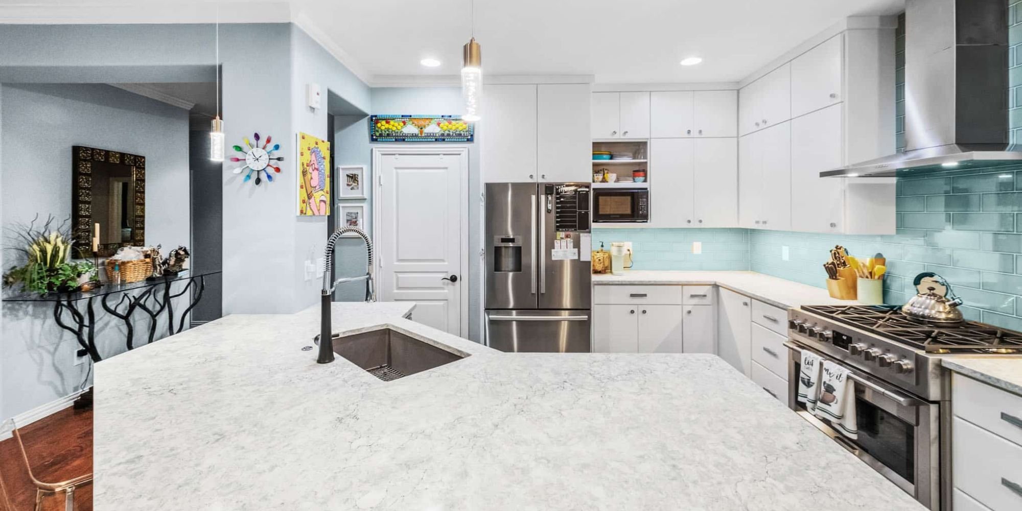 Image of modern kitchen with quartz countertops, white cabinets, and blue tile backsplash in Collin County by Elite Remodeling