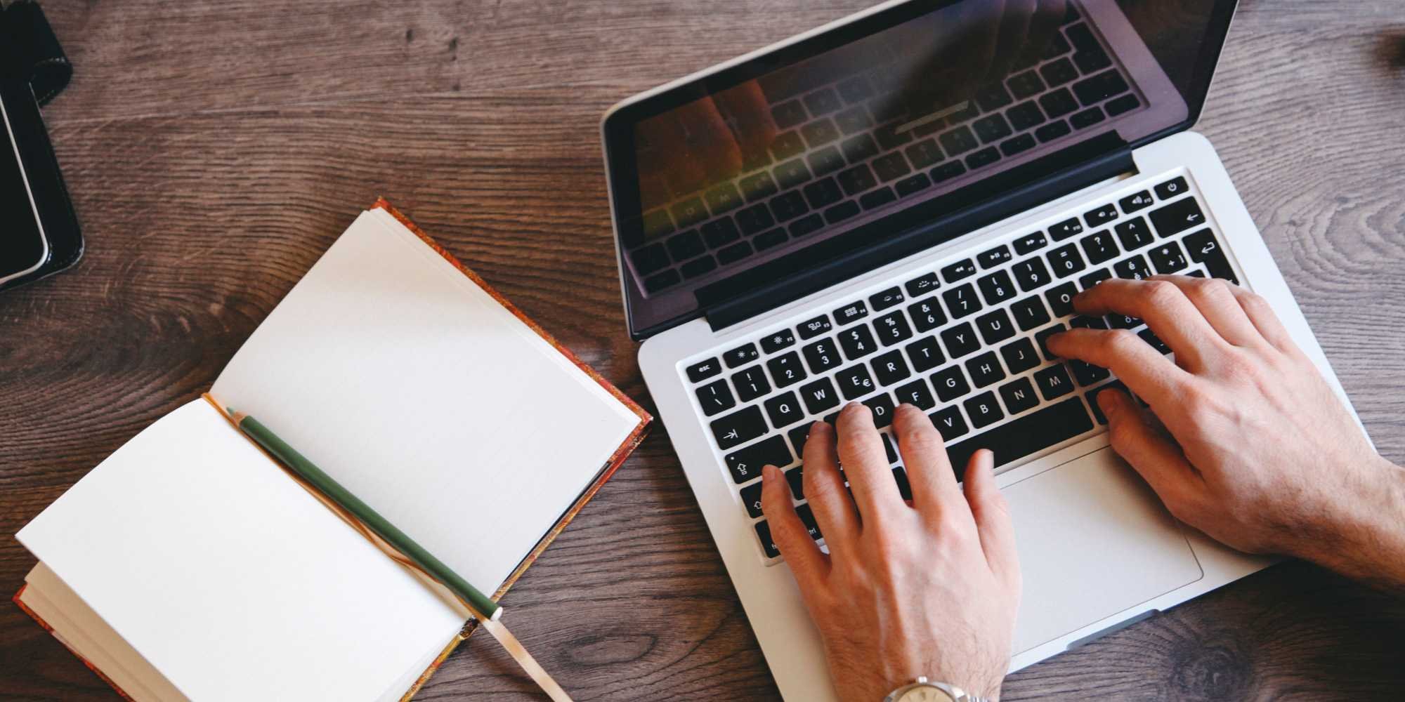 Stock image of a person writing down some questions to ask their remodeler on their laptop