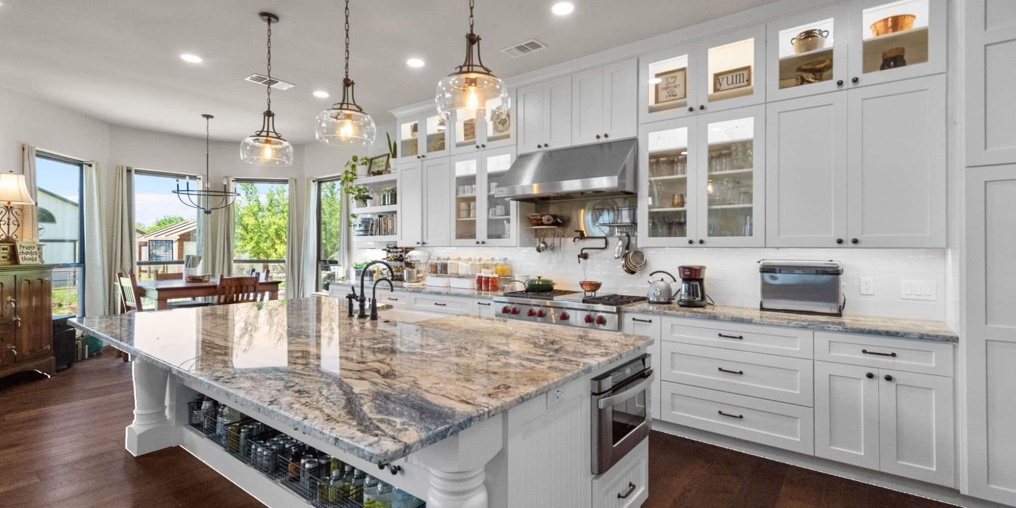 Bright kitchen remodel in Frisco, TX by Elite Remodeling with white cabinetry and a bold granite island