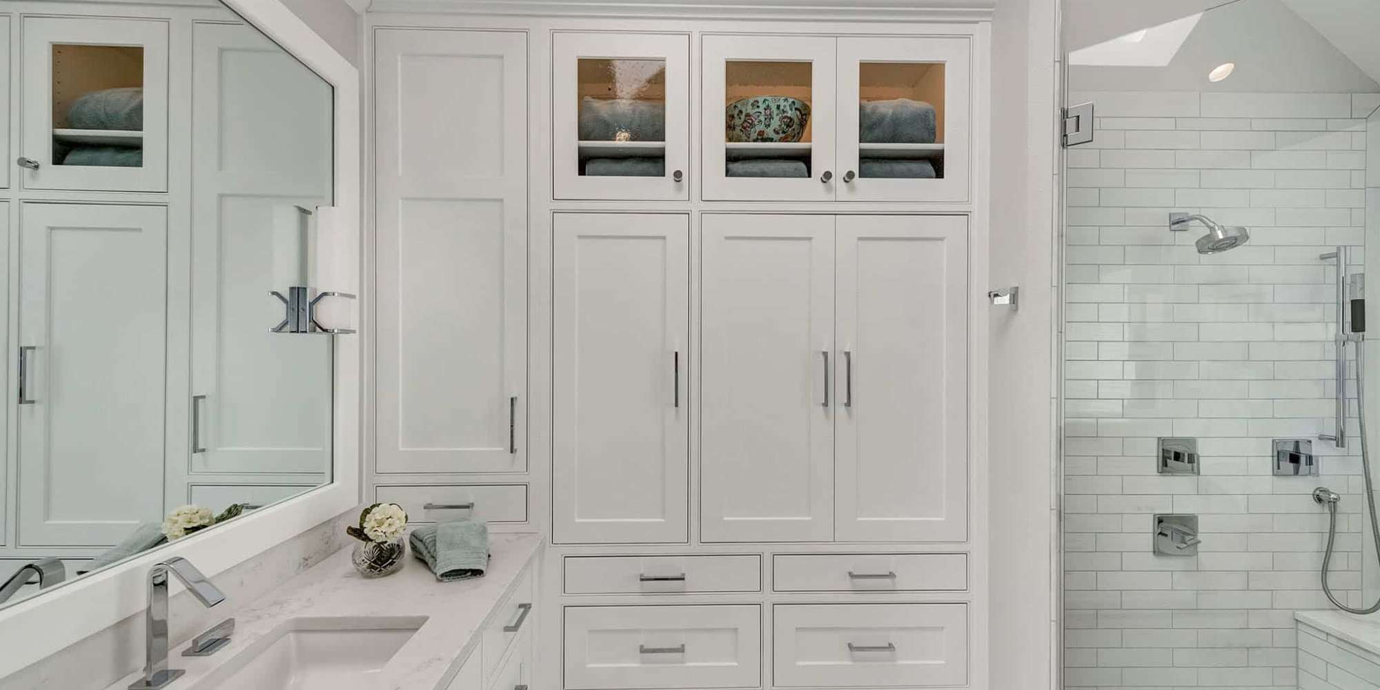 Frisco bathroom design featuring ample cabinet storage and tiled shower wall by Elite Remodeling