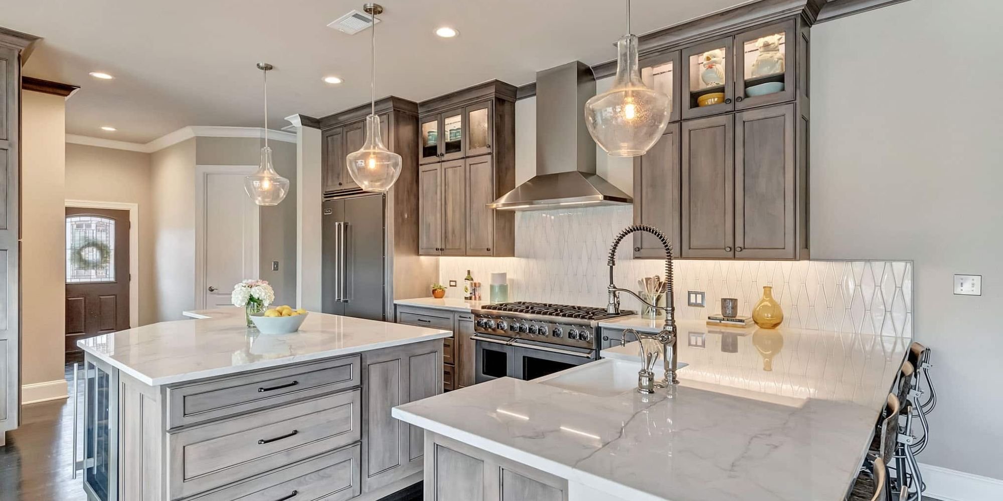 Frisco kitchen remodel featuring under cabinet lighting, marble countertops, and soft wood cabinetry by Elite Remodeling