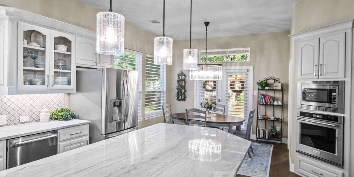 Modern kitchen remodel in Frisco, TX featuring marble countertops and stainless steel appliances by Elite Remodeling