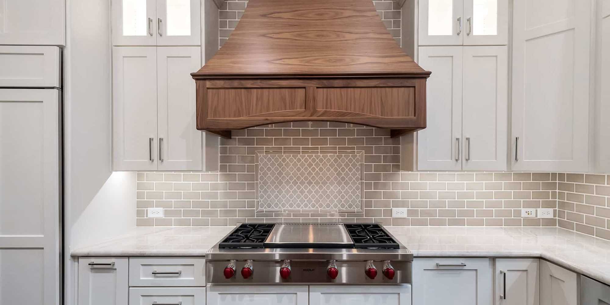 Shaker-style white kitchen cabinets by Elite Remodeling with custom wood range hood in Collin County, TX