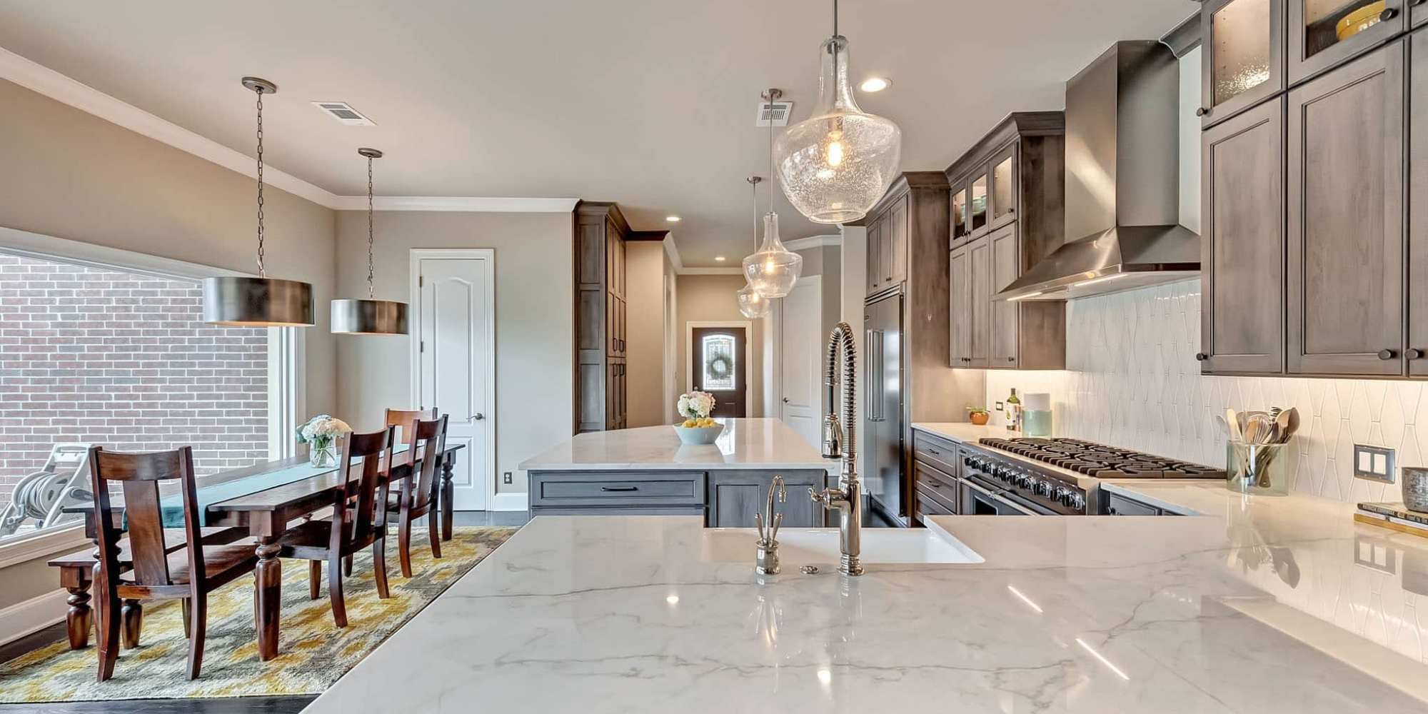 Modern kitchen remodel in Frisco TX by Elite Remodeling with gray cabinets large island and dining area