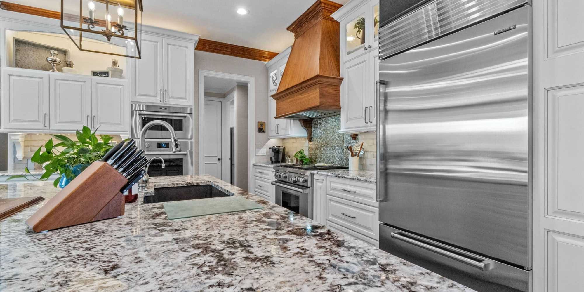 Kitchen remodel in Collin County, TX by Elite Remodeling featuring large island, stone countertops, and professional-grade appliances