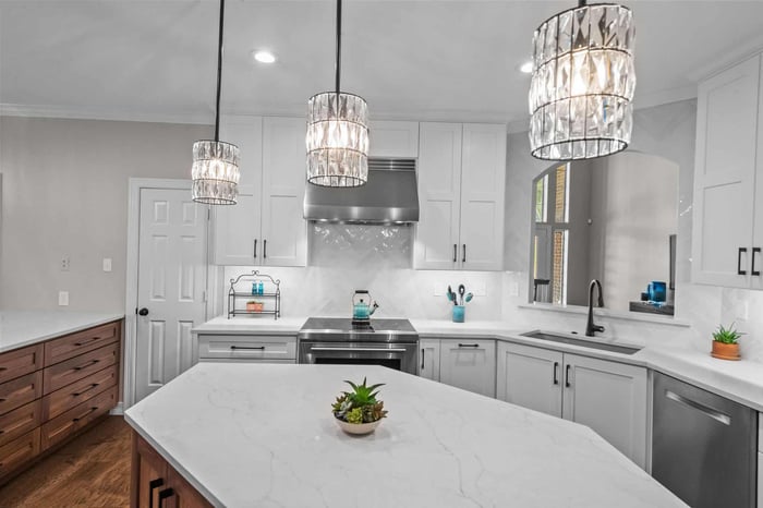 Remodeled kitchen in Frisco, TX featuring stainless steel appliances and wall cut-out through to living room